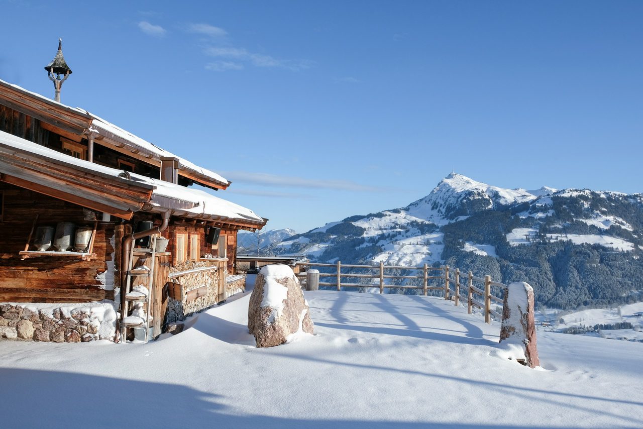 Verschneite Holzhütte mit Bergblick bei Kitzbühel