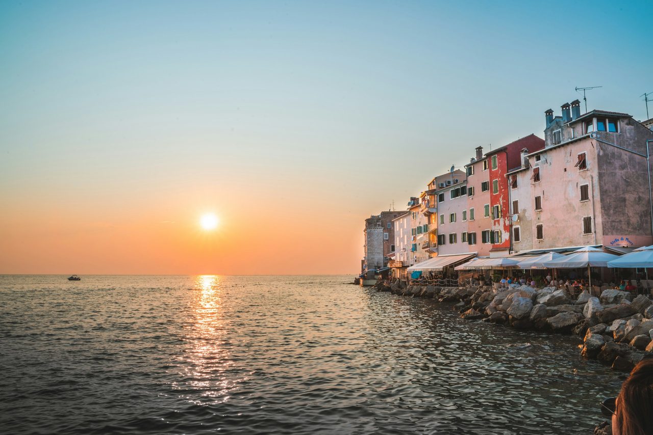 Sonnenuntergang über dem Meer an der Uferpromenade von Rovinj