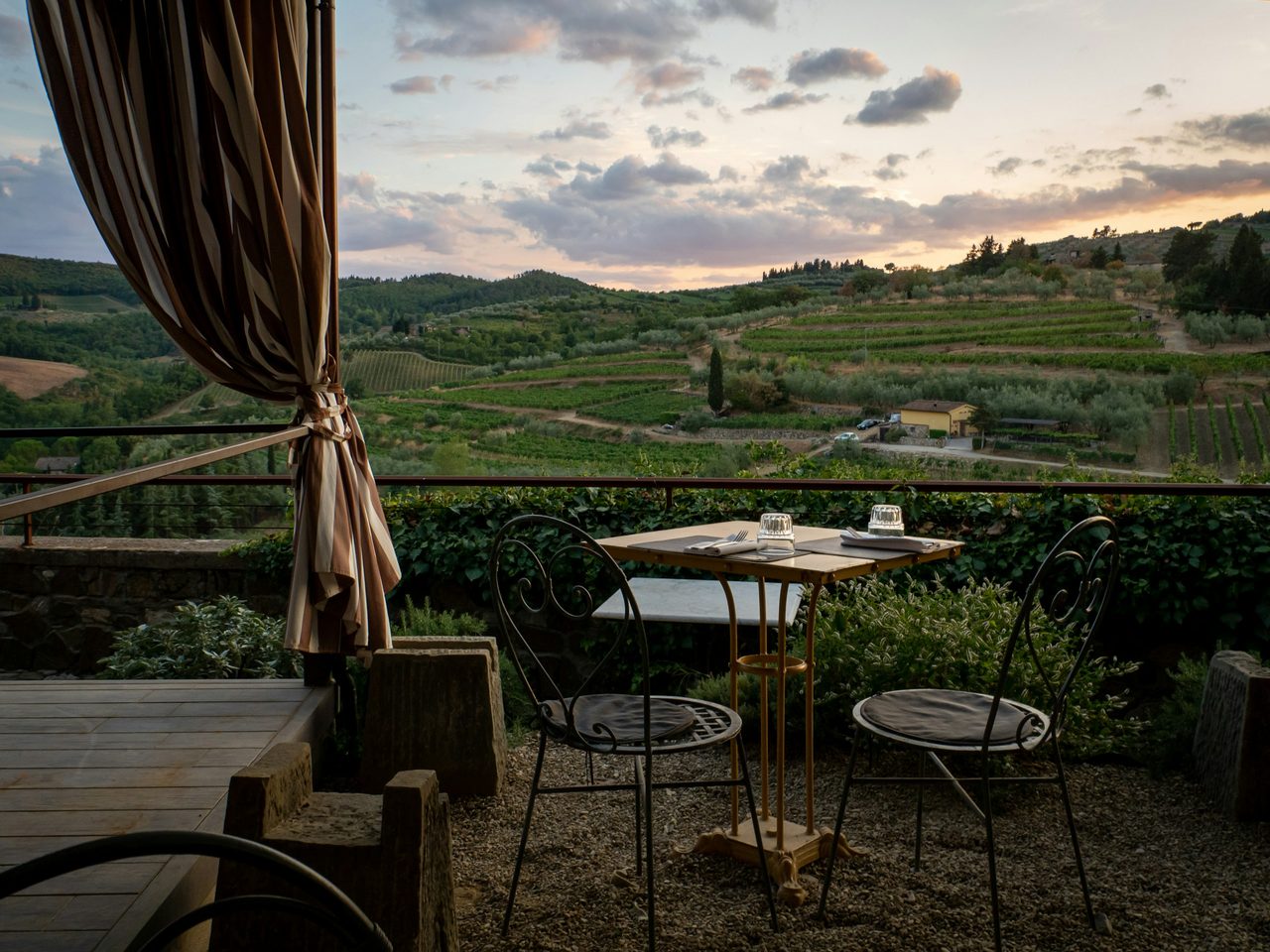 Gedeckter Tisch auf einer Terrasse über den Hügeln der Toskana